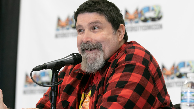 Mick Foley sitting in front of a microphone
