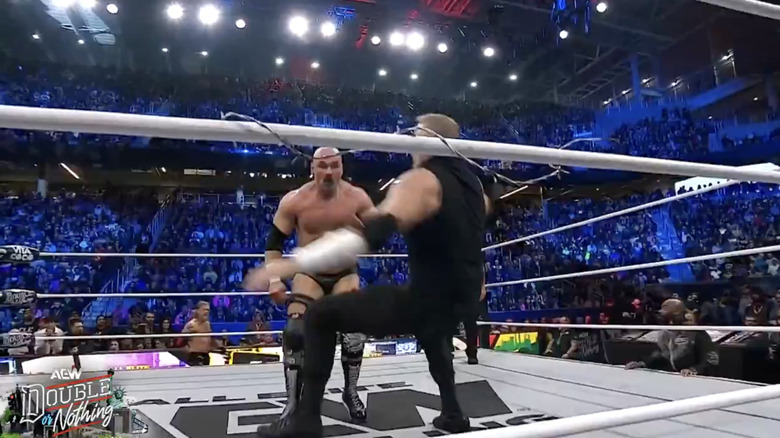 Harwood and Cage in the ring with the middle rope wrapped in barbed wire