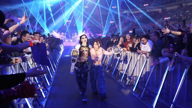 Rhea Ripley & IYO SKY walk down the ramp with their titles on 