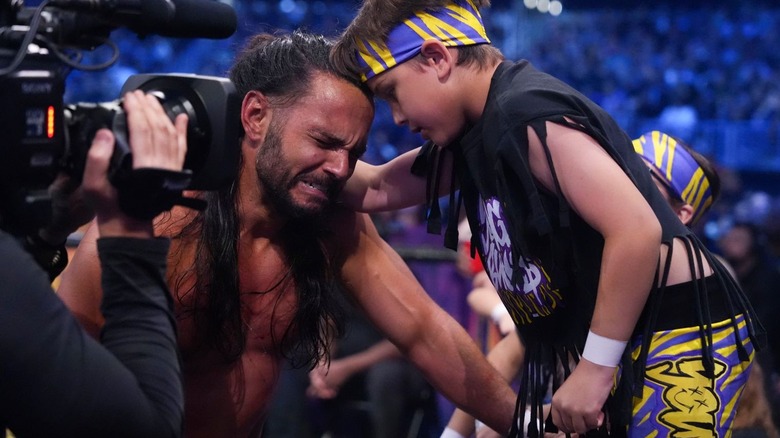 Matt Jackson gets emotional beside a child dressed in purple and yellow at AEW Revolution