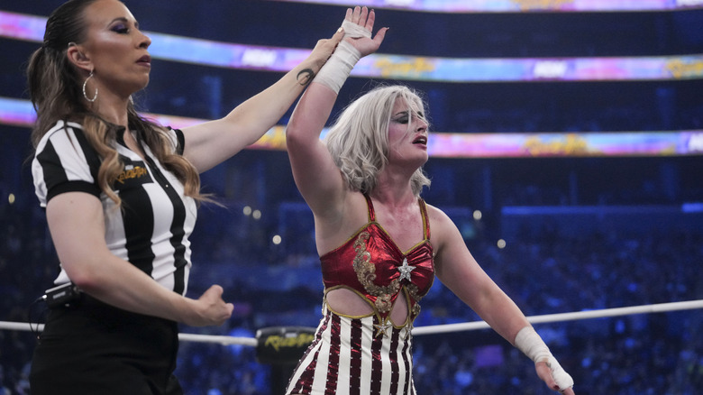 Referee Aubrey Edwards holds up the hand of "Timeless" Toni Storm after her victory over Marina Shafir at AEW Revolution.