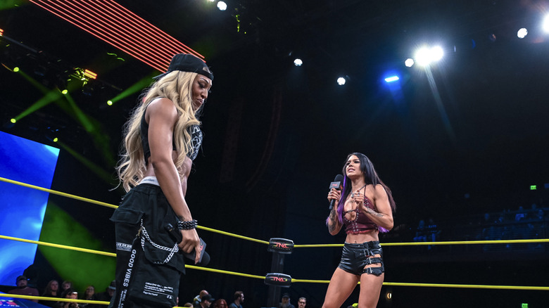 Sadè and Black talking in the ring