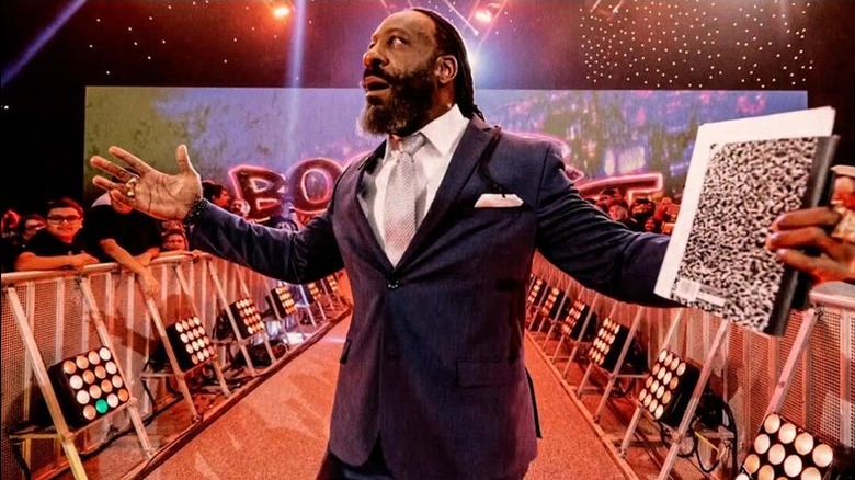 With a notebook in hand full of notes, WWE Hall of Famer Booker T makes his way down to the "NXT" commentary table