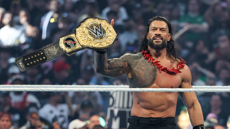 Roman Reigns celebrates with the World Heavyweight Championship