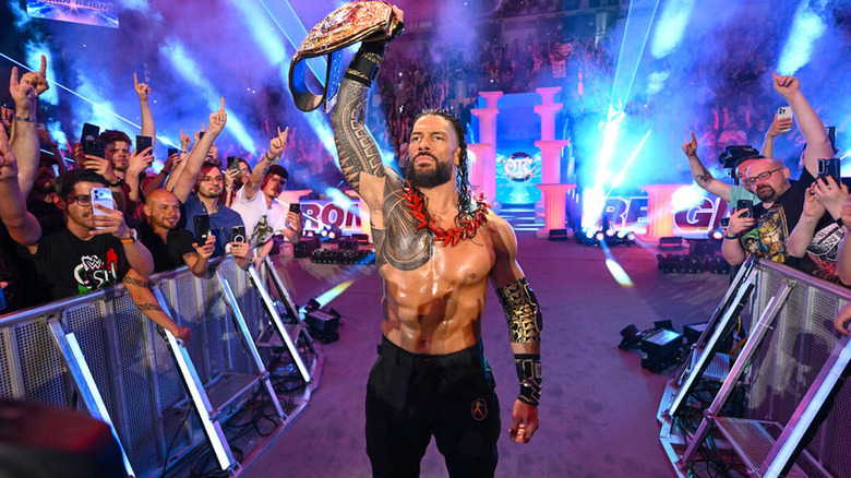 Roman Reigns holding the WWE World Heavyweight Championship in the air