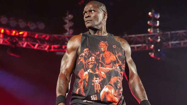 R-Truth standing on the top of the turnbuckle looking out towards the audience.