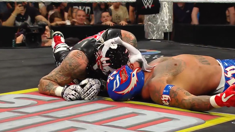 Penta shares a moment with Rey Mysterio after beating him