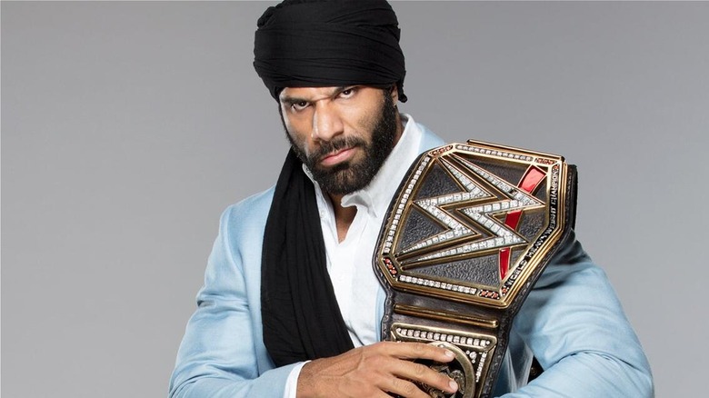 Jinder Mahal posing with the WWE Championship during a photoshoot with his run with the belt.