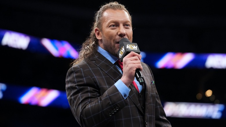 Kenny Omega with a microphone in the ring
