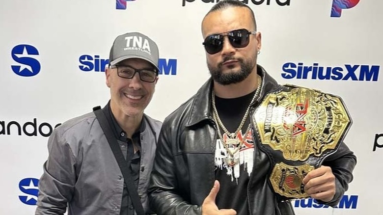 TNA President Carlos Silva smiles on next to TNA World Champion Mike Santana during a press event for the company