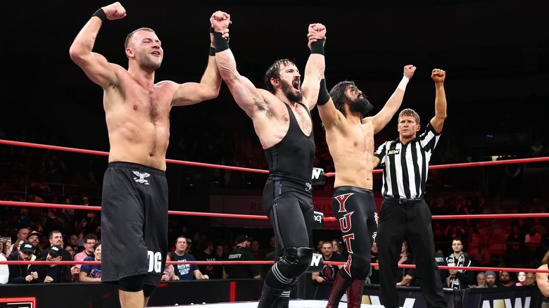 Daniel Garcia, PAC, and Wheeler Yuta with their hands raised