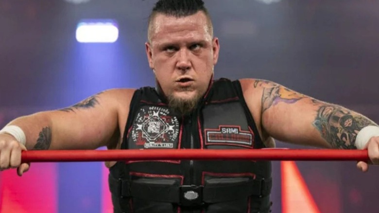 Sami Callihan leans over the ropes and scowls up the ramp after a match in TNA.