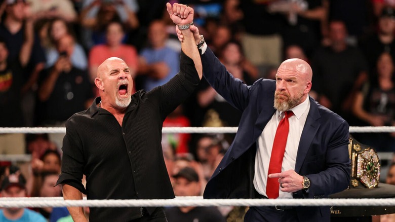 Triple H raises Goldberg's hand in the ring