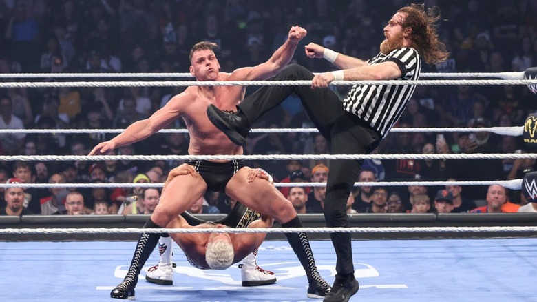 Sami Zayn, serving as the special guest referee, kicks GUNTHER's arms, as he tries to hang on to the ropes to avoid a pin by Undisputed WWE Champion Cody Rhodes, on the June 19, 2026 edition of 