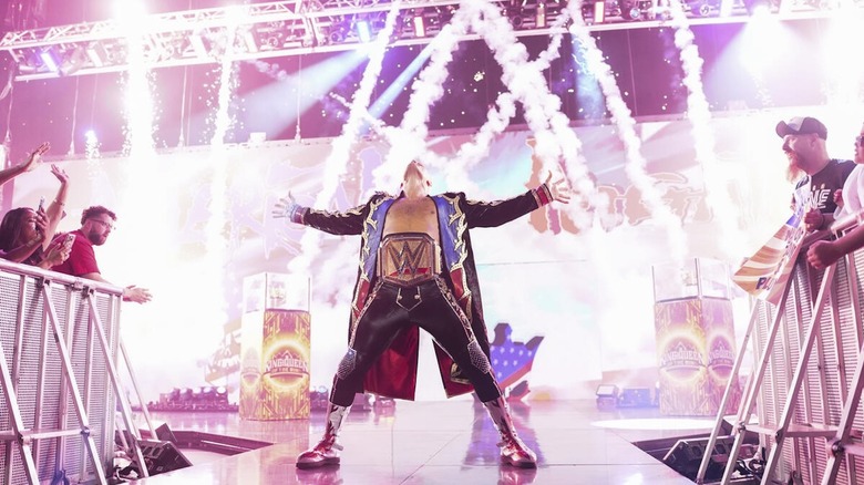 Cody Rhodes poses amidst pyro on the stage on 