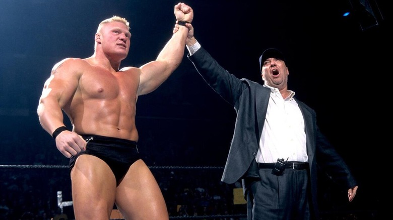Paul Heyman celebrating alongside Brock Lesnar after a win.