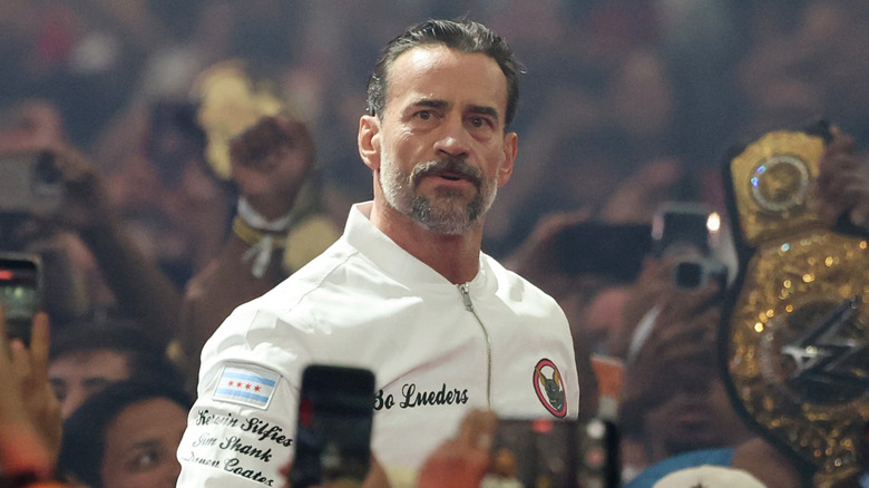 CM Punk with a white jacket on in a crowd