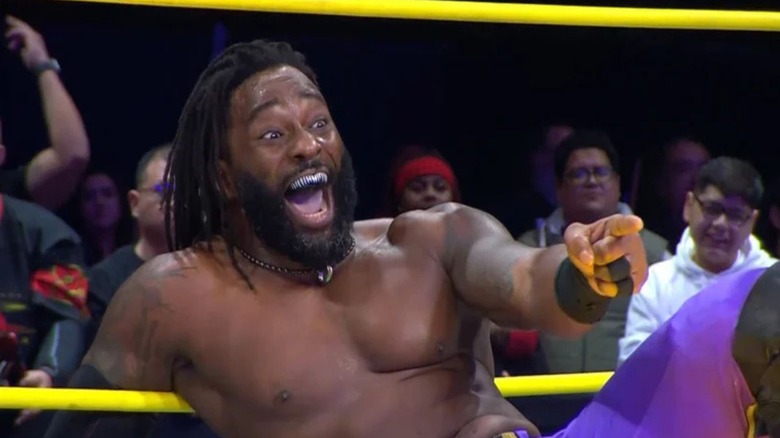 Cedric Alexander laughs and points at an opponent in the ring after a match on 