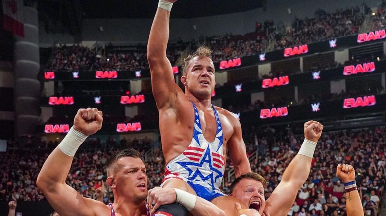 Chad Gable poses, perched on the shoulders of the Creed Brothers, after a victory over Otis in December 2024 on "WWE Raw."