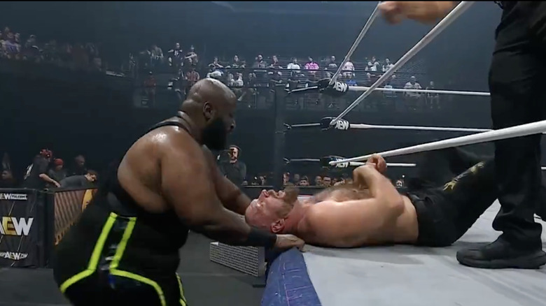 Taylor with Moxley laying on the ring apron
