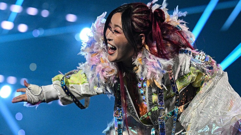 IYO SKY poses on the ropes and smiles toward fans ahead of a match on "WWE SmackDown."