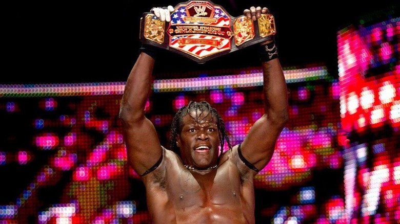R-Truth raising the WWE United States Championship above his head.