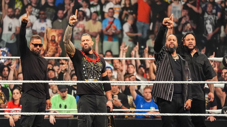 Jey Uso, Roman Reigns, Jimmy Uso, and Jacob Fatu stand in the ring, their ones in the air, during an acknowledgement ceremony on "WWE Raw."