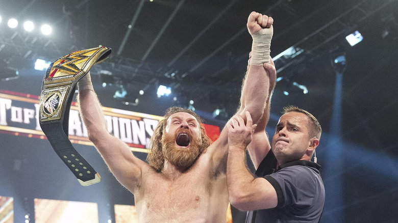 Sami Zayn celebrates with the WWE Title